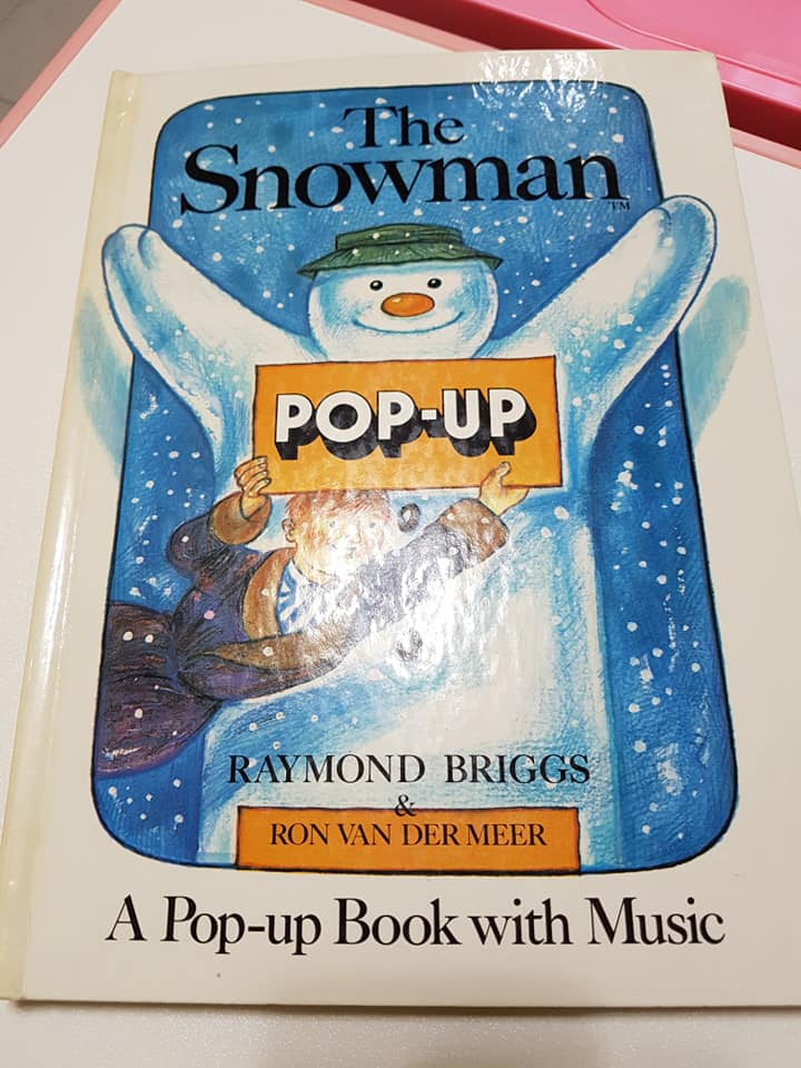 可能是顯示的文字是「 The Snowman POP-UP RAYMOND BRIGGS RON VAN DER MEER A Pop-up Book with Music 」的圖像